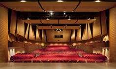 an empty auditorium with rows of red seats