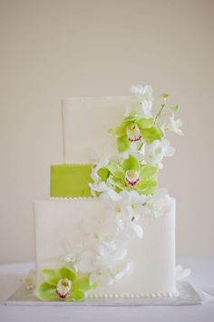 a wedding cake with green and white flowers