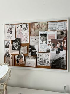 a white desk topped with lots of pictures and magnets on a wall next to a mirror