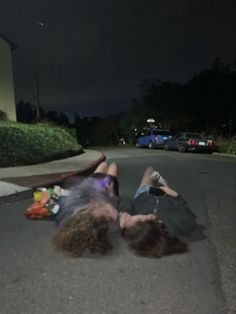 two people laying on the street at night