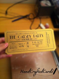 a person holding up a yellow ticket for the gatsby party