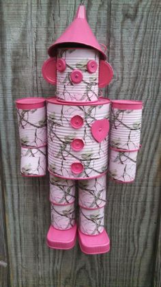 a pink and white robot made out of tin cans