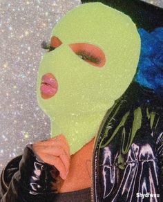 a woman wearing a neon green mask and black jacket