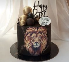 a birthday cake decorated with an image of a lion and some chocolates on top