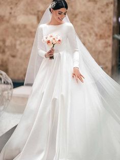 a woman in a white wedding gown and veil