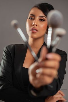 a woman is holding up some spoons in her hand