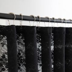 black lace curtains hanging on a metal rod