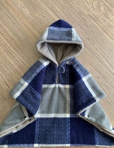 a blue and white checkered hooded jacket on a wooden floor with the hood pulled up