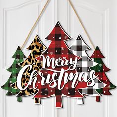 a merry christmas sign hanging on the front door with plaid and leopard print tree decorations