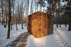 a wooden structure made out of logs in the snow