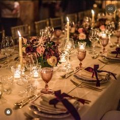 the table is set with candles, plates and silverware for an elegant wedding reception