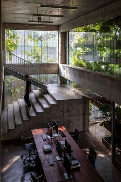 a man is walking up the stairs in an office with wooden desks and chairs