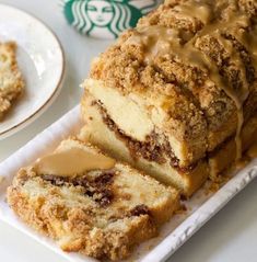 coffee cake on a plate next to a starbucks cup