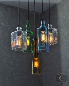 four different colored bottles hanging from a ceiling