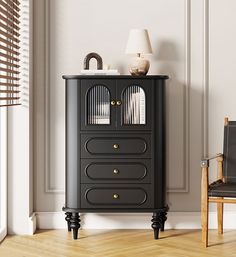 a black cabinet with two doors and three drawers on top of it in front of a chair