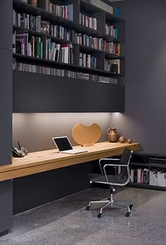 a desk with a laptop on it next to a bookshelf