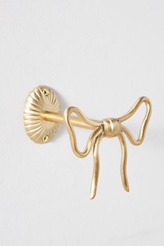 a gold bow tie hook on a white wall