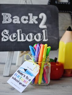 back to school sign with colorful pens and pencils in a jar on a table