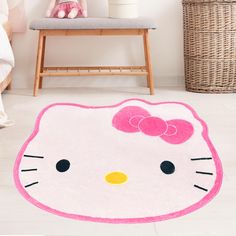 a pink hello kitty rug on the floor in a child's room with a chair