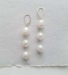 Make a chic statement in these triple pearl drop earrings. Plump with a shimmering luster, these genuine freshwater pearls are delicately hand wrapped. They securely dangle from lever backs, bold yet comfortable.



Heirloom quality, these earrings are available in your choice of sterling silver or 14kt gold fill. Both fresh and timeless - a pearl lovers dream! Pearl And Silver Earrings, Three Pearl Earrings, Steamboat Wedding, Pearl Ideas, Wedding Earrings Gold, Silver Pearl Drop Earrings, Drop Earrings Pearl, Pearl Wedding Earrings, Pearl Earrings Designs