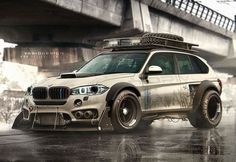 a white bmw suv parked in front of a bridge on a rainy day with its lights on