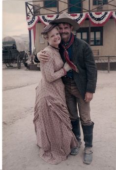 a man standing next to a woman in front of a building