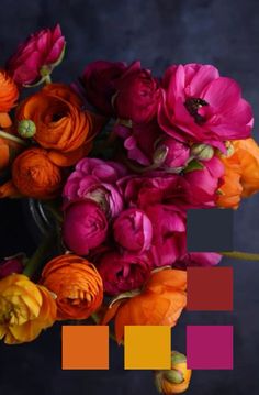 a vase filled with lots of colorful flowers on top of a black table next to an orange and pink color scheme