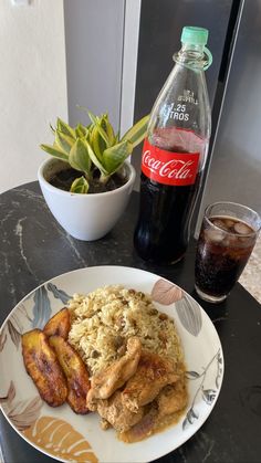 a plate with chicken, rice and fruit next to a bottle of coca - cola