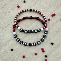 Show your support for the Arizona Diamondacks with this 2-Bracelet set for the AZ sports fan. Let's Go Diamondbacks! 2 pack Serpientes and D-Backs bracelets.  Represent our National League Champions with two hand-crafted, beaded, stretch friendship bracelets.   Great Christmas gift for sports fans and teens. Designed to be stackable, you can wear these bracelets together for a bold statement or mix and match with other accessories to create your unique look.  Not only are these bracelets a great Casual Red Personalized Name Bracelet, Game Day Black Wristband With Letter Beads, Personalized Red Casual Wristband, Red Personalized Casual Wristband, Black Beaded Bracelets With Letter Beads For Game Day, Personalized Black Sporty Bracelets, Sporty Personalized Black Bracelets, Sporty Personalized Black Bracelet, Casual Black Name Bracelet For Friendship