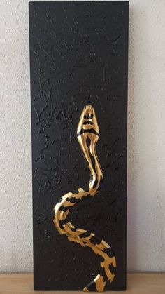 a black and gold painting on a wall