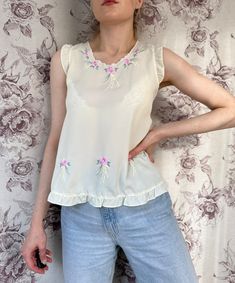 - Vintage faded yellow romantic top with pink floral embroidery  - Good vintage condition  - TAG SIZE: no information  - Fabric information: 100% polyester Estimated to fit XS-S-M based on your desired fit. Measurements (laying flat): - Shoulders (back): 33 cm - Length: 59 cm - Armpit to armpit: 45 cm Vintage clothes may come with minor flaws due to pre-loved wear. But most importantly it is a one-of-a-kind piece with its own character. By shopping secondhand you're giving a second life and not Beige Feminine Tops With Floral Embroidery, Feminine Cream Tank Top For Spring, Delicate White Sleeveless Top, Feminine Embroidered Cream Tops, Feminine Cream Embroidered Tops, Sleeveless Floral Embroidered Top For Summer, Sleeveless Spring Embroidered Top With Floral Embroidery, Sleeveless Embroidered Floral Top For Spring, Sleeveless Embroidered Top With Floral Design For Spring