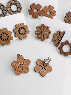 several wooden flower shaped magnets sitting on top of a white table next to each other