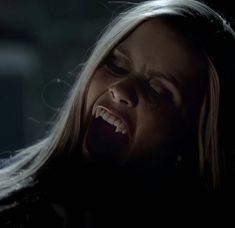 a woman with her mouth open in the dark