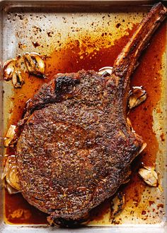 a piece of steak on a pan with mushrooms and seasoning sprinkled around it