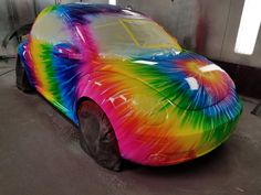 a car painted in rainbow colors sitting on the ground