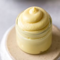 a jar filled with cream sitting on top of a white plate