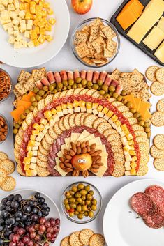 a turkey shaped platter surrounded by cheeses, crackers, and other snacks