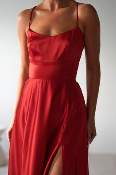 a woman in a long red dress posing for the camera