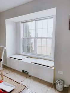 an empty room with some windows in the middle and tools on the floor next to it