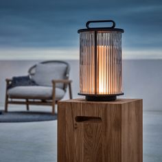 a light that is sitting on top of a wooden block in front of a chair