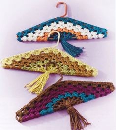 three crocheted scarves with tassels hanging from hooks