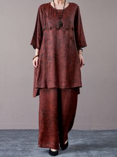 Elevate your everyday style with this rust brown two-piece set, featuring a relaxed-fit tunic and matching wide-leg pants. The tunic is adorned with subtle decorative accents for added charm, while the wide-leg pants ensure comfort and ease of movement. Perfect for casual wear or a laid-back evening look, this set can be accessorized with statement jewelry and classic footwear for a sophisticated finish. Key Features: Soft rust brown fabric Relaxed-fit tunic with decorative accents Comfortable wide-leg pants Easy-to-wear two-piece set Ideal for casual and evening wear Brown Long Sleeve Sets For Spring, Casual Fall Sets With Wide-leg Pants, Casual Brown Workwear Sets, Brown Wide Leg Sets For Spring, Casual Brown Sets With Relaxed Fit, Casual Brown Relaxed Fit Set, Casual Red Wide Leg Sets, Summer Workwear Sets In Brown, Brown Two Piece