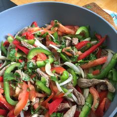 a blue bowl filled with vegetables and meat