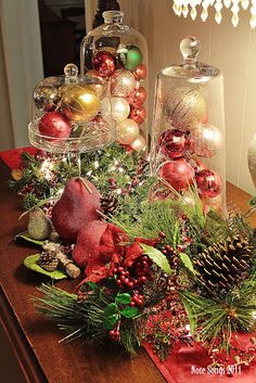 a wooden table topped with lots of christmas decorations and baubles on top of it