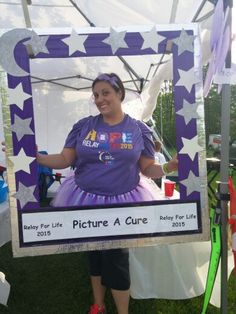 a woman standing in front of a purple and white photo frame with stars on it