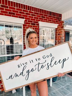 a woman holding up a sign that says give it to god and go to sleep