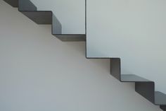 a white wall and some stairs in a room with no one on the ground or standing up