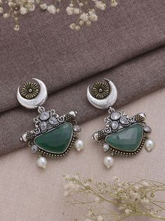 Dive into the realm of sophistication and charm with our Dual Tone Green Chandbali Earrings, a harmonious blend of tradition and contemporary flair. These earrings boast a graceful design adorned with exquisite half-moon detailing, showcasing the artisanal finesse that makes them a true embodiment of elegance. The dual tone green color palette imparts a refreshing and playful vibe, making them a versatile accessory that effortlessly transitions from day to night, from casual gatherings to festive celebrations. Meticulously crafted with precision, these earrings not only serve as a visual delight but also symbolize a timeless statement piece. Elevate your style effortlessly as you embrace the fusion of classic and modern aesthetics, allowing these Dual Tone Green Chandbali Earrings to becom Luxury Green Chandbali Jhumkas, Metal Chandbali Danglers With Intricate Design, Bollywood Style Kundan Chandbalis In Dual-tone, Bollywood Style Dual-tone Kundan Chandbalis, Festive Dual-tone Kundan Chandbalis, Dual-tone Chandbali Metal Earrings, Metal Chandbali Bridal Earrings, Elegant Oxidized Chandbalis For Festivals, Silver Metal Chandbalis For Wedding