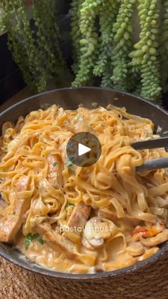 a bowl filled with pasta and meat on top of a table