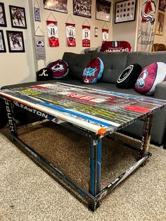 a living room with a couch, table and sports memorabilia on the wall behind it